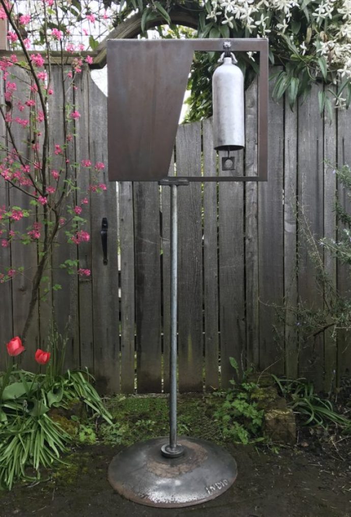 Aluminum Bell with Stainless Steel Accent- 24" W x 64" H. Created from fire extinguisher, laser cut drop, chain, square washer, vintage twist drill wood handle, stainless steel cable, plow disc and plumbing from my bathroom remodel.